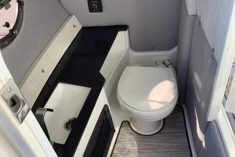 Slide: The Image of 2022 Cobalt R6 Surf boat interior bathroom with toilet and sink. - 6
