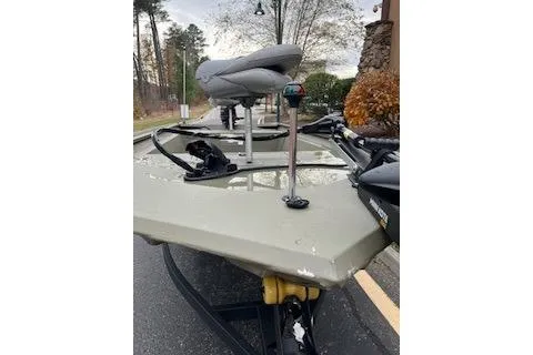 Slide: The Image of 2025 Tracker Grizzly 1754 AWL boat with seating and equipment, parked outdoors. - 4