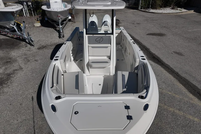 Slide: The Image of 2026 Sailfish 252 CC boat, spacious deck, sleek design, parked on concrete surface. - 10