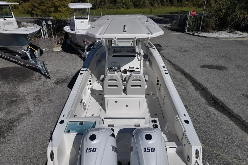 Slide: The Image of 2026 Sailfish 252 CC boat with dual Yamaha 150 engines, parked on asphalt. - 16