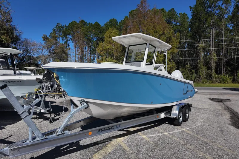 Slide: The Image of 2026 Sailfish 252 CC boat on trailer, parked outdoors with trees in background. - 4