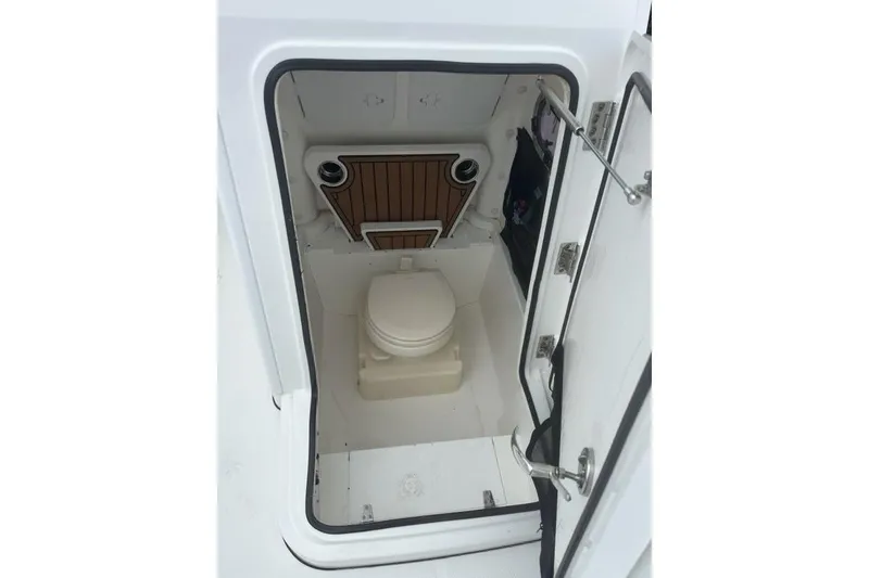 Slide: The Image of 2022 Edgewater 230CC boat interior with compact marine toilet. - 13