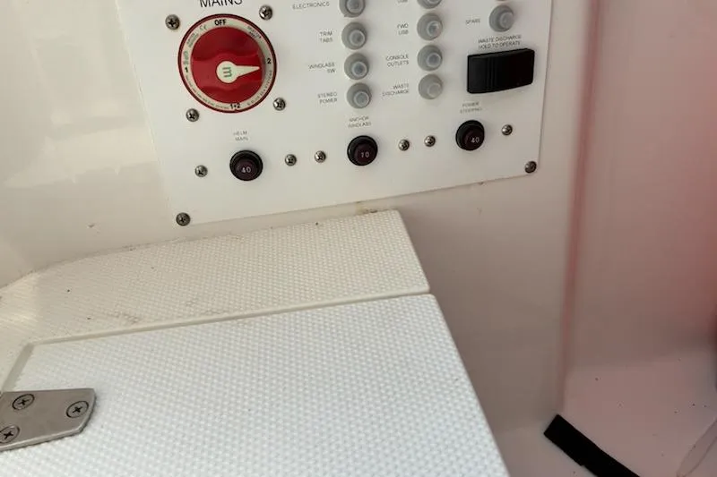 Slide: The Image of Control panel of a 2022 Edgewater 230CC boat with switches and dials. - 14