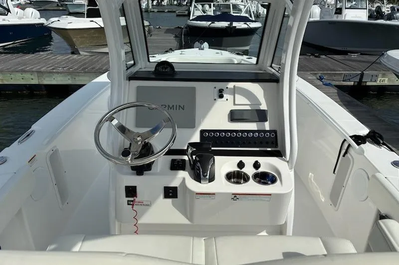 Slide: The Image of 2022 Edgewater 230CC boat cockpit with steering wheel and control panel. - 2