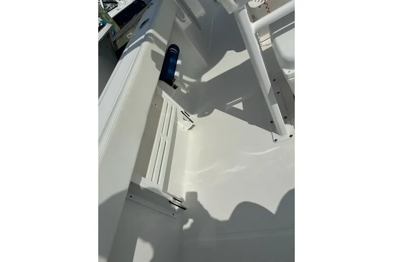 Slide: The Image of Interior of 2022 Edgewater 230CC boat, featuring white seating and storage area. - 23