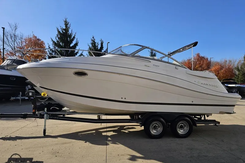 Slide: The Image of 2008 Four Winns V258 boat on trailer, parked outdoors under clear blue sky. - 14
