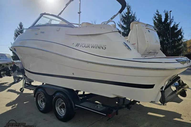 Slide: The Image of 2008 Four Winns V258 boat on trailer, parked outdoors under sunlight. - 18