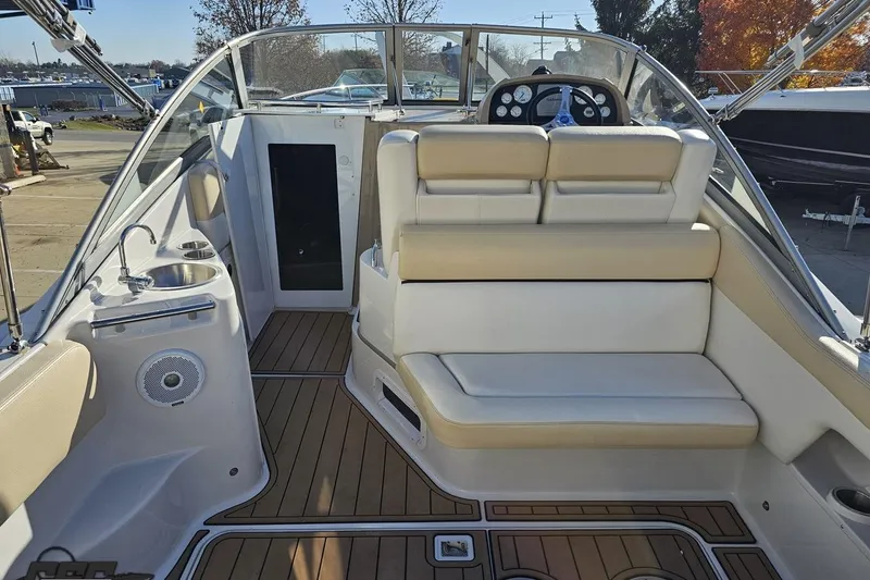Slide: The Image of 2008 Four Winns V258 boat interior with seating, sink, and steering wheel. - 25
