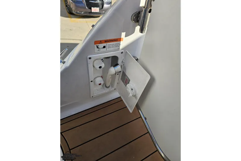 Slide: The Image of 2008 Four Winns V258 boat deck with open utility panel and warning label. - 28