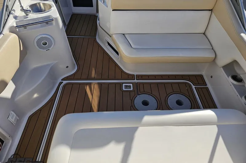 Slide: The Image of 2008 Four Winns V258 boat interior with wood flooring and beige seating. - 29