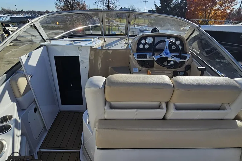 Slide: The Image of 2008 Four Winns V258 boat interior with steering wheel and beige seating. - 37