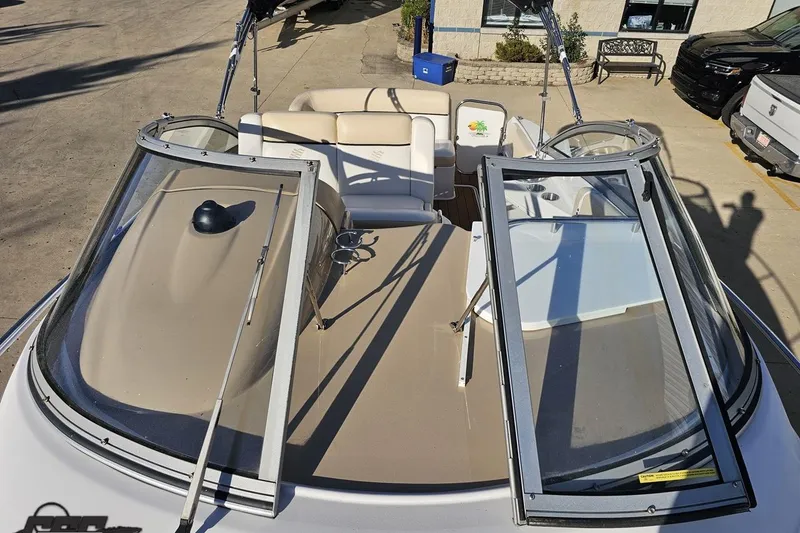 Slide: The Image of 2008 Four Winns V258 boat with open windshield and beige seating, parked outdoors. - 54
