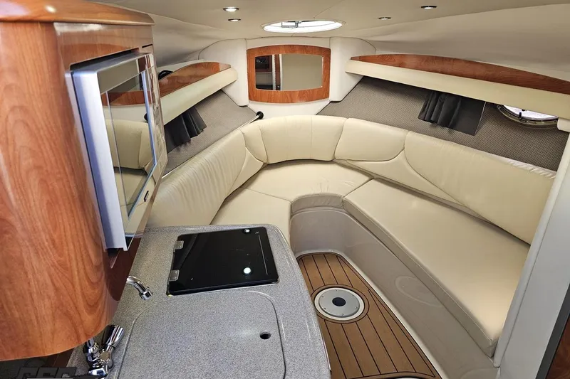 Slide: The Image of 2008 Four Winns V258 boat interior with beige seating, wood accents, and kitchenette. - 61