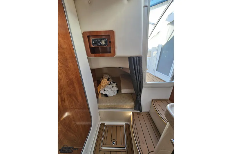 Slide: The Image of Interior cabin of 2008 Four Winns V258 boat with wooden accents and seating area. - 73