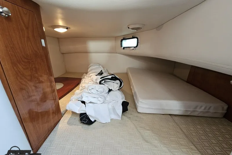 Slide: The Image of 2008 Four Winns V258 cabin interior with bed, wooden cabinet, and porthole window. - 78