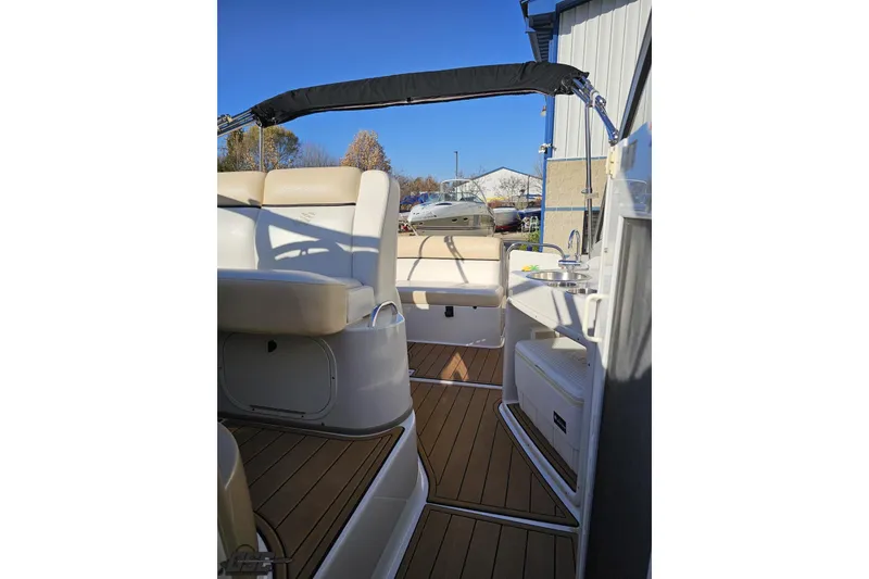 Slide: The Image of 2008 Four Winns V258 boat interior with seating and kitchenette under blue sky. - 81