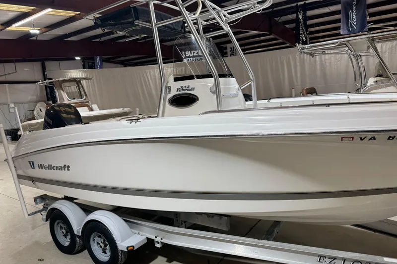The Image of 2007 Wellcraft 232 Fisherman boat on trailer in indoor showroom. - 0