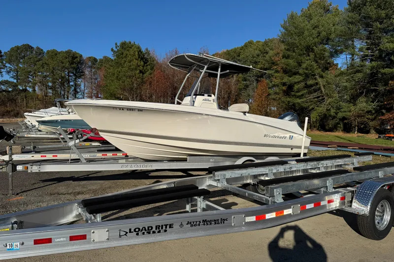 Slide: The Image of 2007 Wellcraft 232 Fisherman boat on trailer, surrounded by trees and a garage. - 1