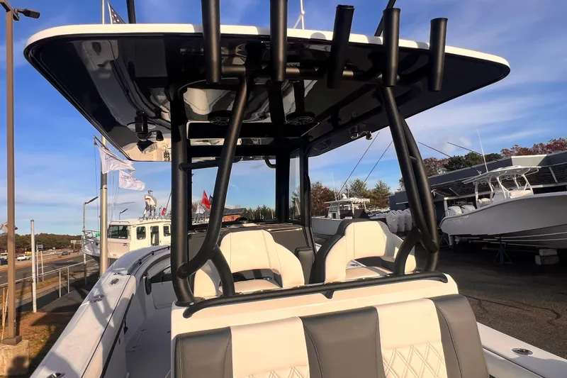 Slide: The Image of 2026 Yellowfin 36 Offshore boat with T-top and rod holders, docked under clear sky. - 15