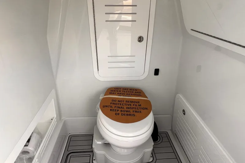 Slide: The Image of 2026 Yellowfin 36 Offshore boat bathroom with protective film on toilet seat. - 16