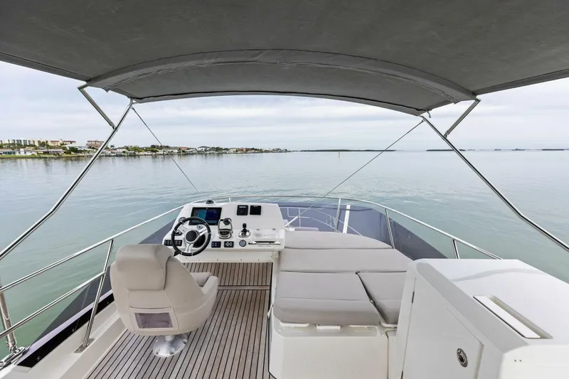 Slide: The Image of 2022 Prestige 420 yacht helm with serene waterfront view. - 2