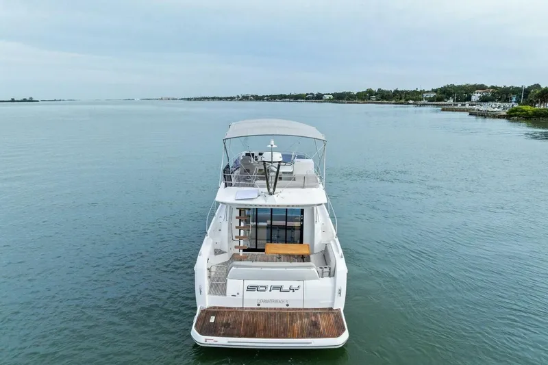 Slide: The Image of 2022 Prestige 420 yacht on calm water, rear view with open deck and canopy. - 55