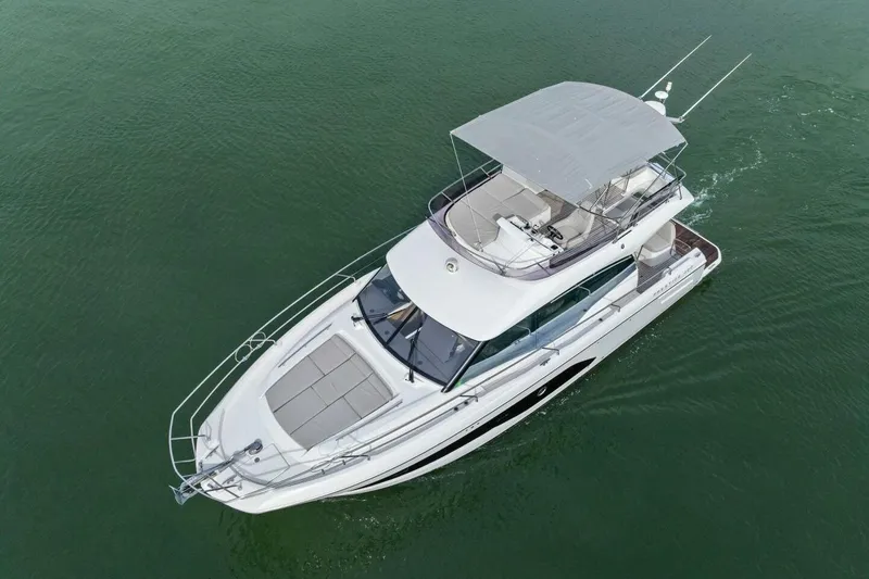 Slide: The Image of 2022 Prestige 420 yacht cruising on calm green waters, aerial view. - 57