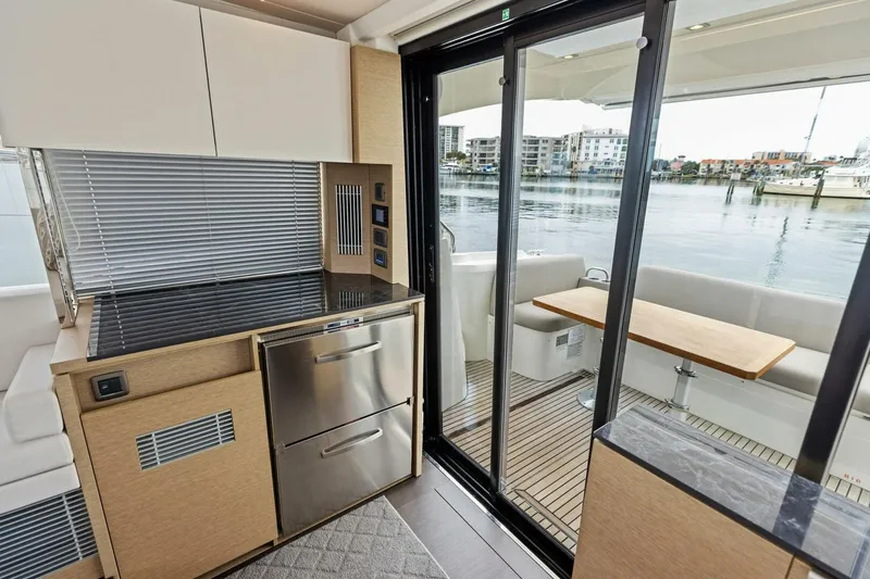 Slide: The Image of Modern kitchen and dining area on 2022 Prestige 420 yacht with waterfront view. - 8
