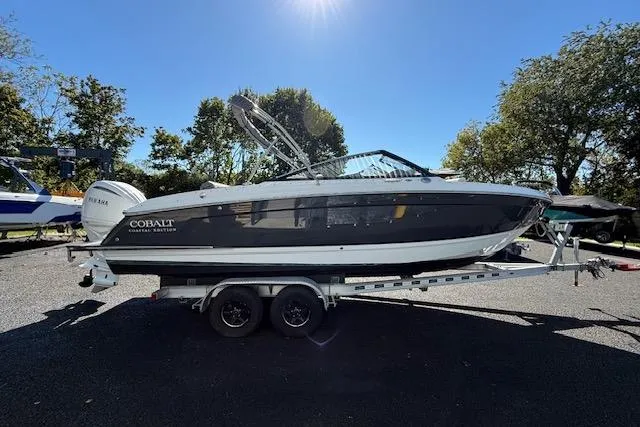 The Image of 2025 Cobalt R4 Outboard boat on trailer, parked outdoors under clear blue sky. - 0