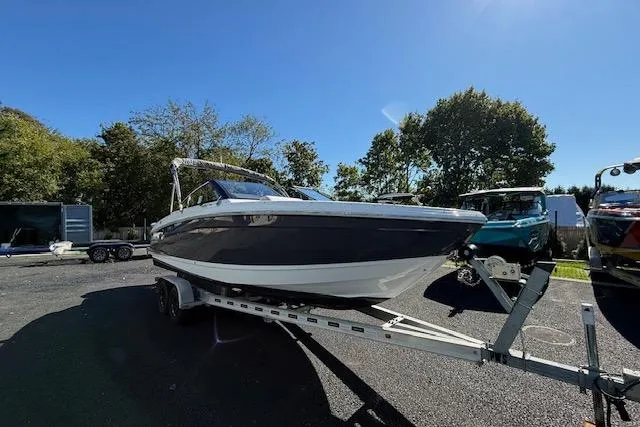 Slide: The Image of 2025 Cobalt R4 Outboard boat on trailer, parked outdoors under clear blue sky. - 4