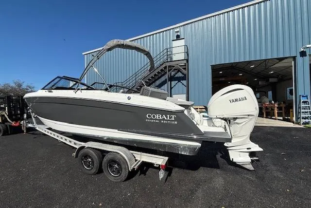 Slide: The Image of 2025 Cobalt R4 Outboard boat with Yamaha engine on trailer, parked outside a warehouse. - 5