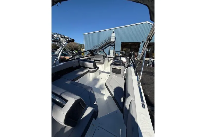 Slide: The Image of 2025 Cobalt R4 Outboard boat interior with seating, parked near a blue building. - 9