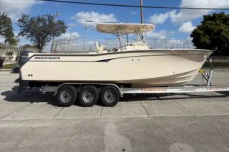 Slide: The Image of 2007 Grady-White Bimini 306 boat on trailer, parked outdoors under blue sky. - 7