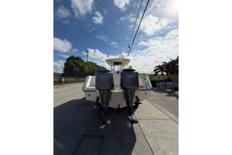 Slide: The Image of 2007 Grady-White Bimini 306 boat with dual 250 horsepower engines, parked under a blue sky. - 8