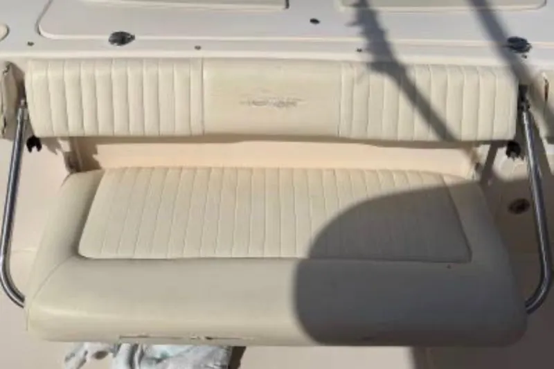 Slide: The Image of 2007 Grady-White Bimini 306 boat seat with white upholstery and metal supports. - 9
