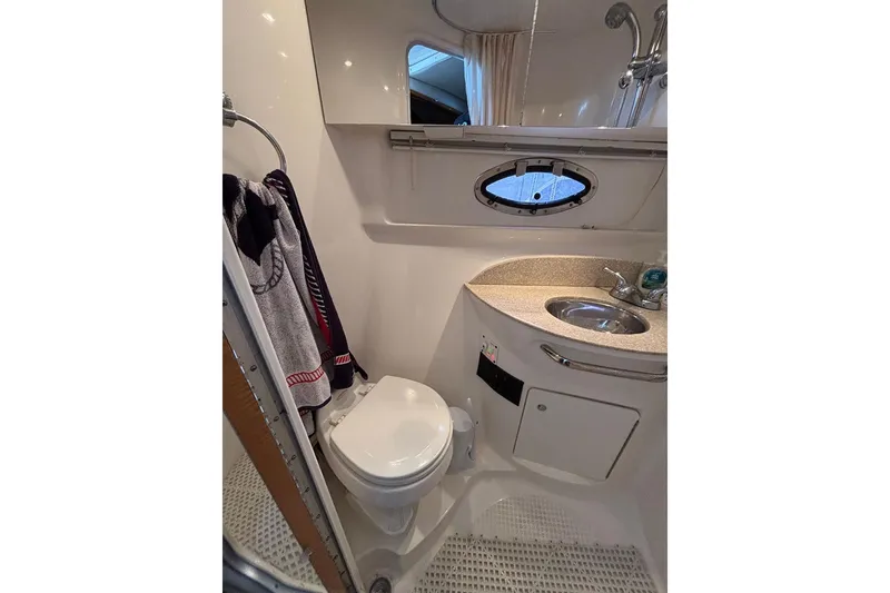 Slide: The Image of 2006 Chaparral Signature 350 bathroom with toilet, sink, and porthole window. - 21