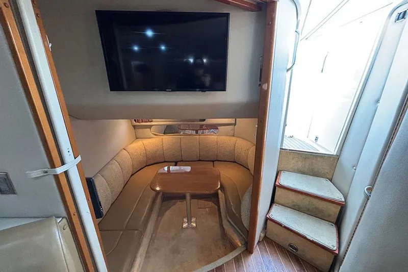 Slide: The Image of 2006 Chaparral Signature 350 interior with cozy seating, table, and mounted TV. - 23