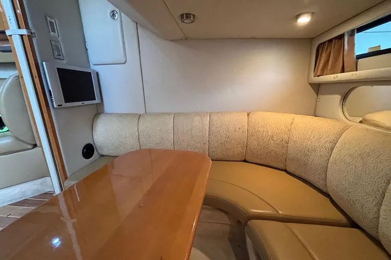 Slide: The Image of 2006 Chaparral Signature 350 interior with curved seating and wooden table. - 27