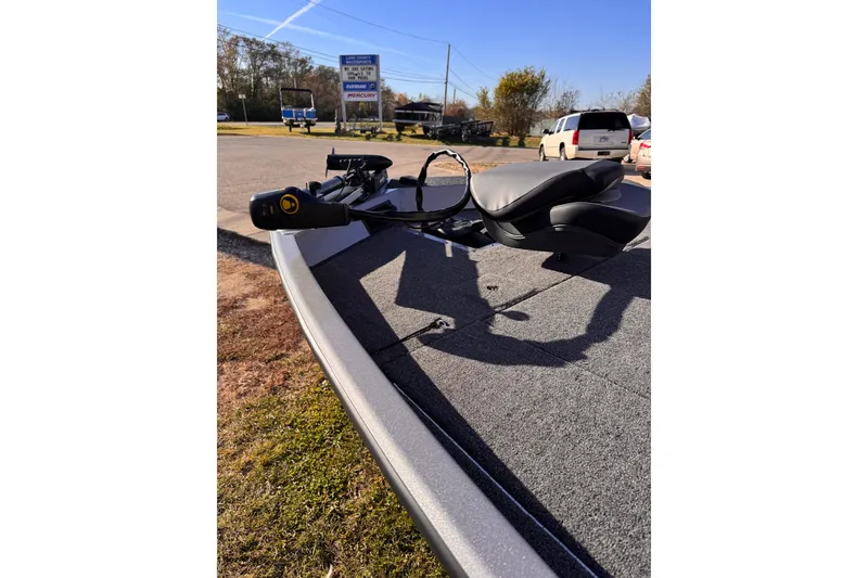 Slide: The Image of 2026 Lowe Stinger 175C boat deck with seat and motor, parked outdoors. - 10