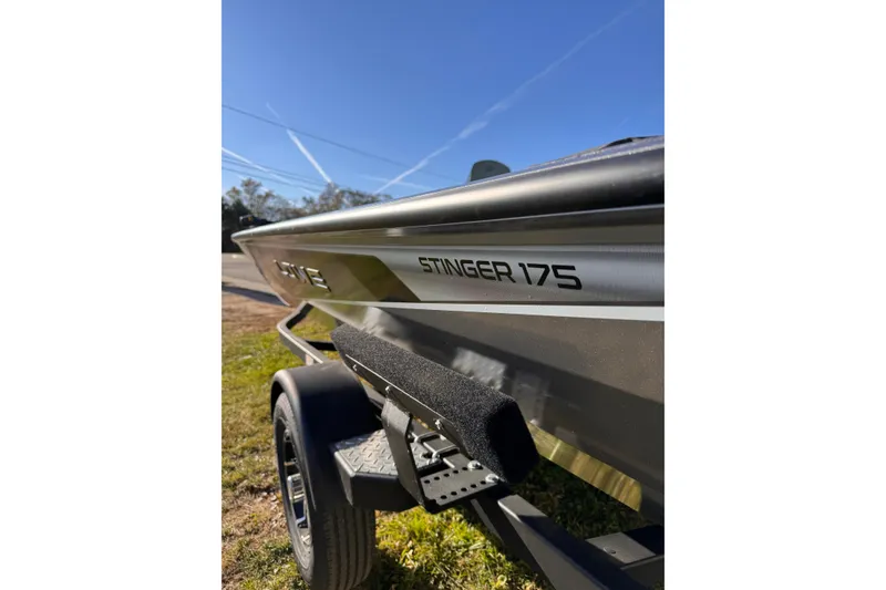 Slide: The Image of 2026 Lowe Stinger 175C boat on trailer under clear blue sky. - 9