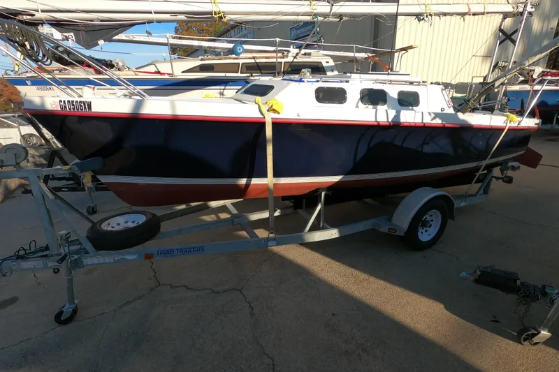 The Image of 1996 Rhodes 22 sailboat on a trailer, parked outdoors in a marina setting. - 0
