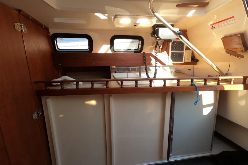 Slide: The Image of Interior of a 1996 Rhodes 22 sailboat with wooden cabinetry and control panel. - 10