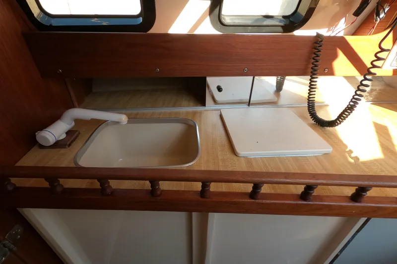 Slide: The Image of 1996 Rhodes 22 boat interior with sink and countertop in natural light. - 11