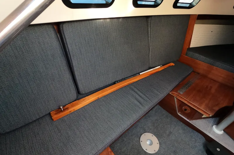 Slide: The Image of Interior of a 1996 Rhodes 22 sailboat with cushioned seating and wooden accents. - 13