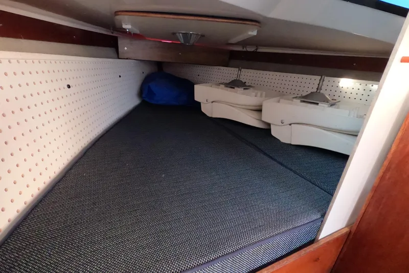 Slide: The Image of Interior cabin view of a 1996 Rhodes 22 sailboat, featuring storage space and equipment. - 16