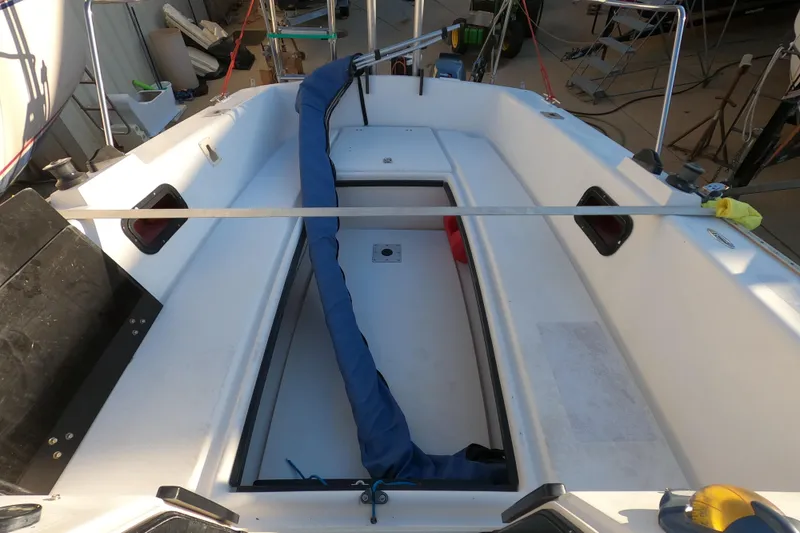 Slide: The Image of 1996 Rhodes 22 sailboat cockpit with blue sail cover and storage compartments. - 19