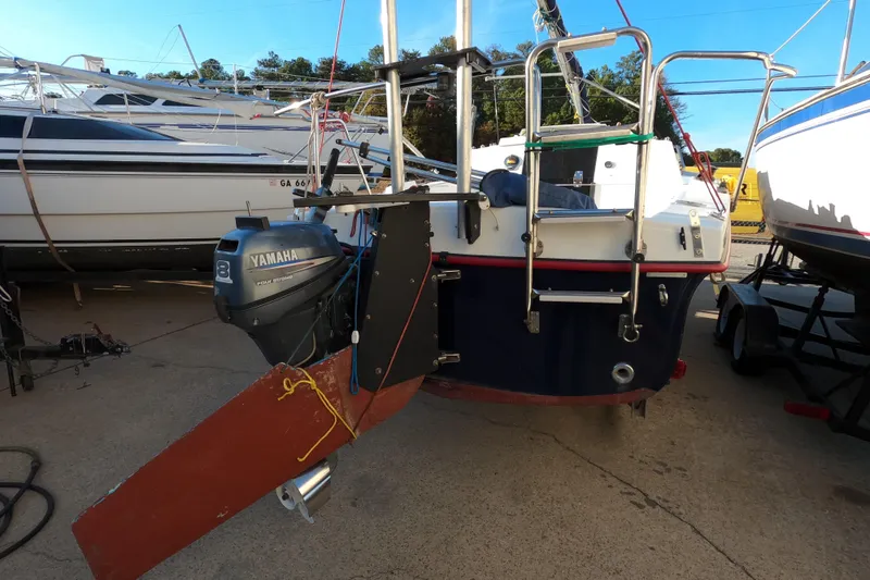 Slide: The Image of 1996 Rhodes 22 sailboat with Yamaha outboard motor, docked in a marina. - 2
