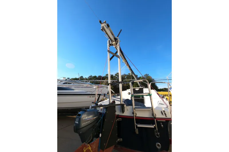 Slide: The Image of 1996 Rhodes 22 sailboat with Yamaha outboard motor, docked under clear blue sky. - 3