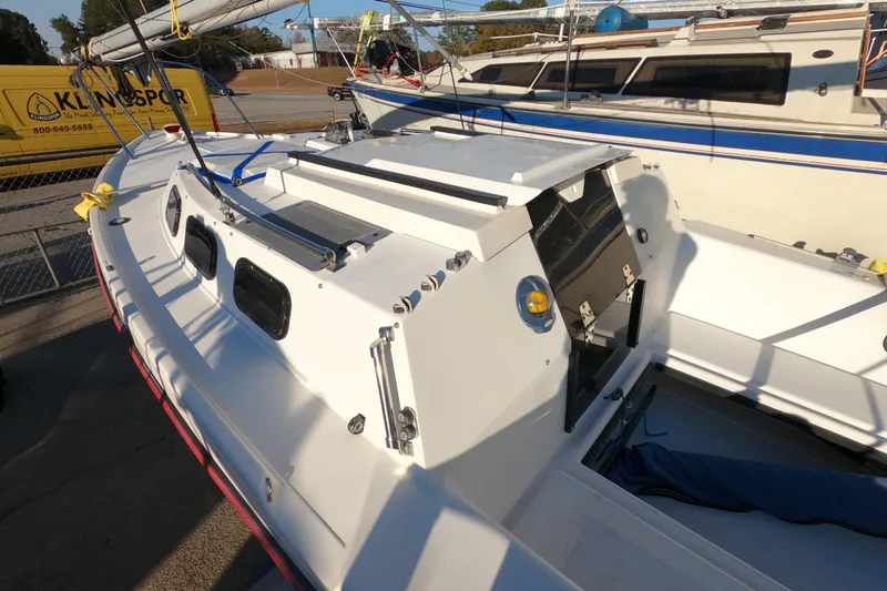 Slide: The Image of 1996 Rhodes 22 sailboat with white deck and cabin, docked near other boats. - 4
