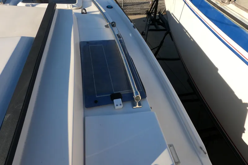 Slide: The Image of 1996 Rhodes 22 sailboat deck with railing and hatch, docked beside another boat. - 7